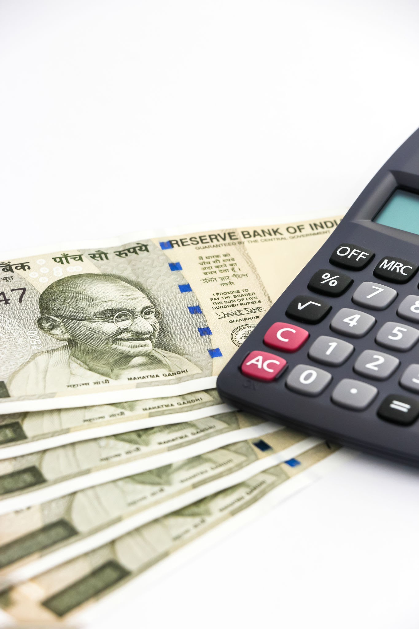 Indian currency and a calculator representing financial matters and maintenance.