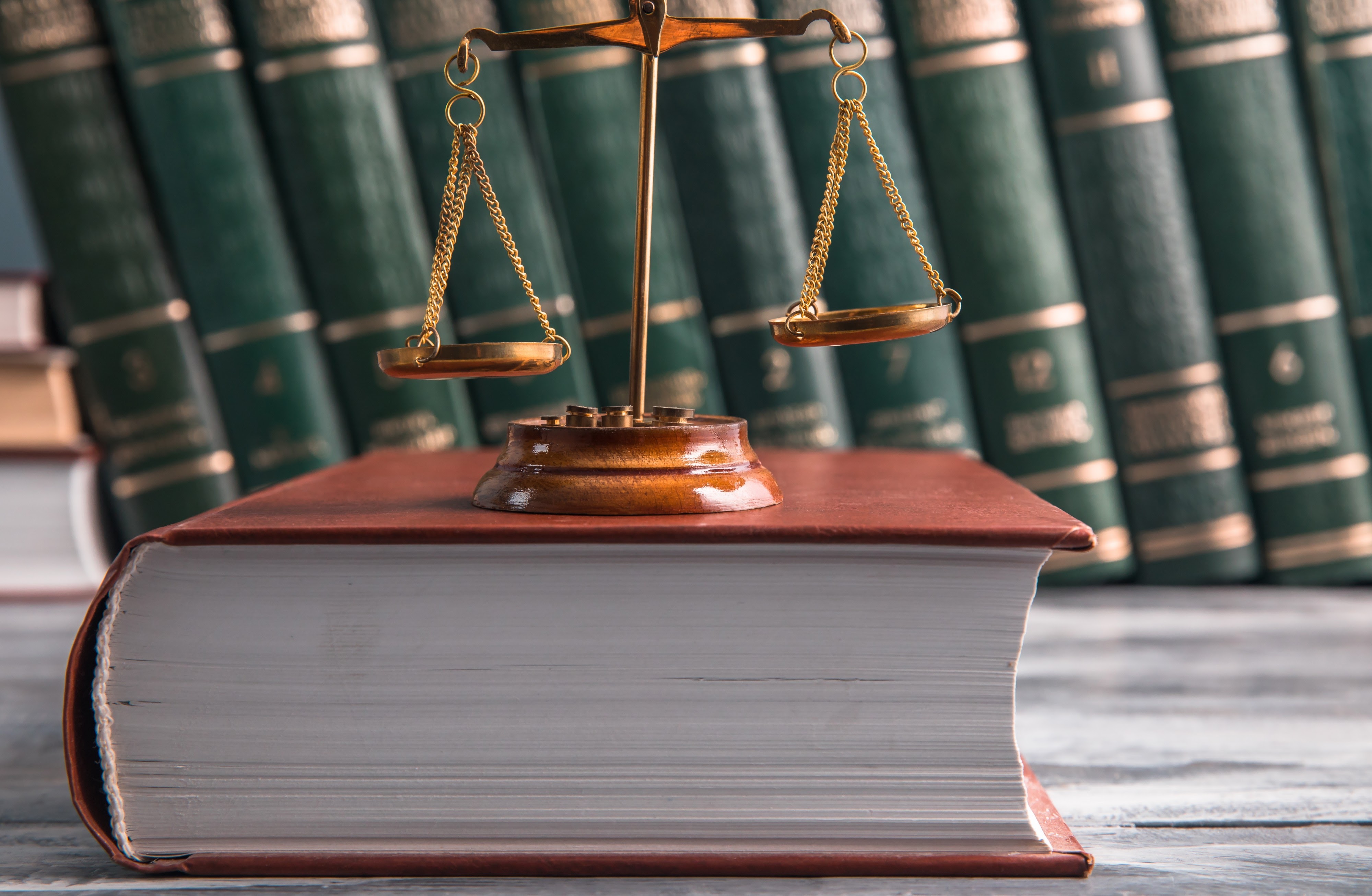 Scales of justice and a law book symbolizing legal defense.